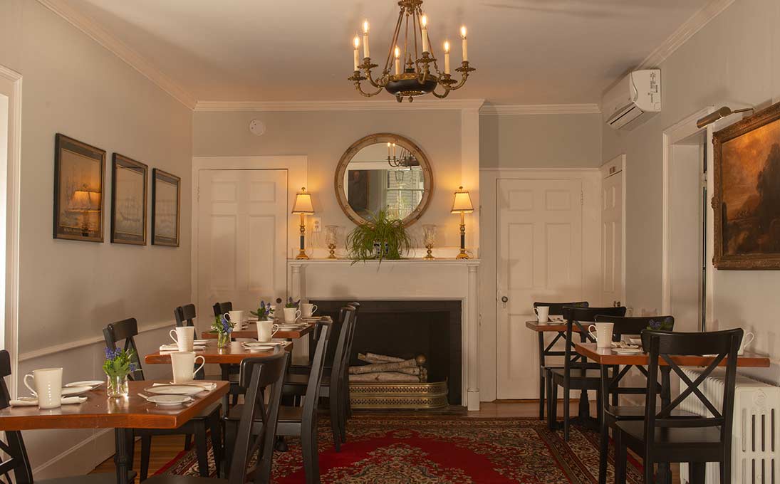 Indoor traditional dining room with five separate tables, fireplace and chandelier
